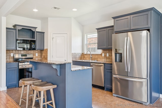 13323 S 21st St, Bixby, OK 74008 - kitchen featuring stainless steel appliances, light stone counters, a kitchen breakfast bar, a center island, and backsplash