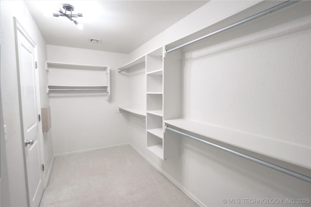walk in closet featuring visible vents and light carpet