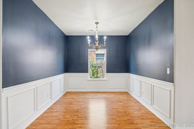13323 S 21st St, Bixby, OK 74008 - spare room with a chandelier, light wood-style floors, wainscoting, and a decorative wall