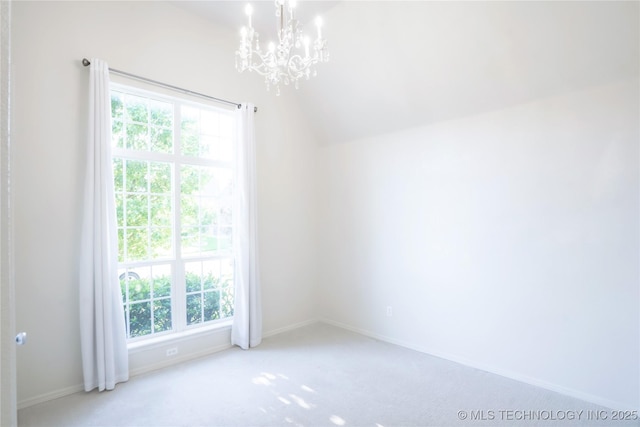 carpeted empty room featuring baseboards, an inviting chandelier, plenty of natural light, and vaulted ceiling