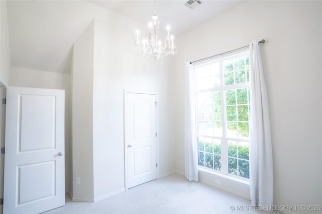 unfurnished bedroom featuring visible vents, carpet flooring, baseboards, and a notable chandelier