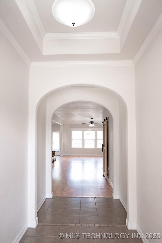 13323 S 21st St, Bixby, OK 74008 - hallway featuring a tray ceiling, arched walkways, baseboards, and crown molding