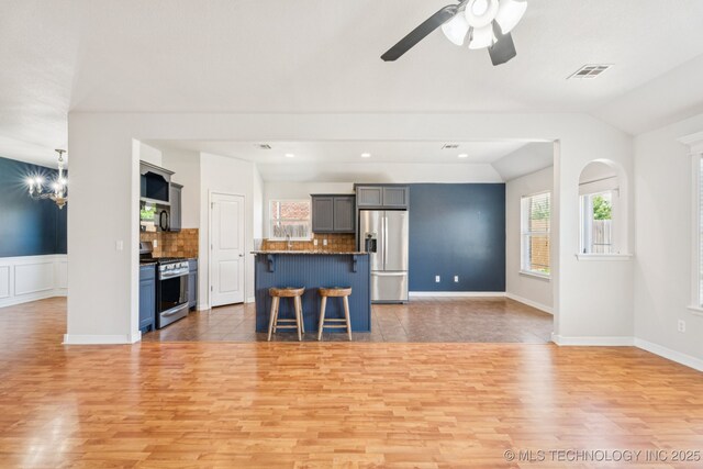 13323 S 21st St, Bixby, OK 74008 - kitchen with stainless steel appliances, a kitchen breakfast bar, light wood-type flooring, open floor plan, and lofted ceiling