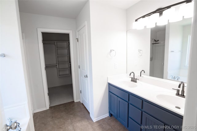 13323 S 21st St, Bixby, OK 74008 - full bathroom with a garden tub, double vanity, a walk in closet, tile patterned floors, and baseboards
