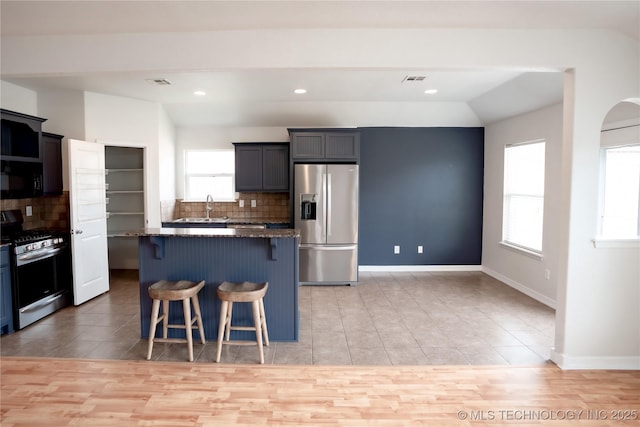 13323 S 21st St, Bixby, OK 74008 - kitchen featuring appliances with stainless steel finishes, a kitchen breakfast bar, tasteful backsplash, a center island, and recessed lighting