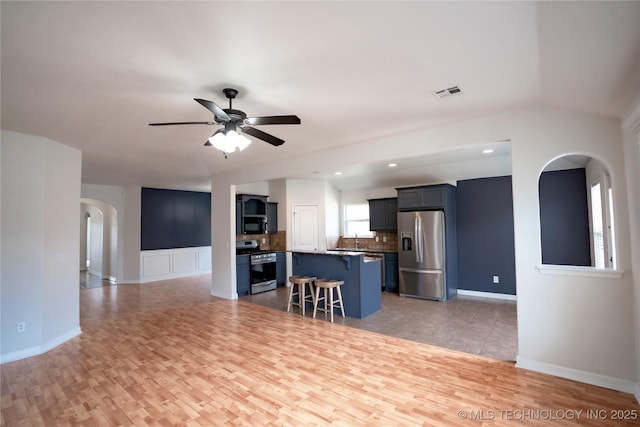 13323 S 21st St, Bixby, OK 74008 - living room featuring arched walkways, light wood-style flooring, ceiling fan, and baseboards