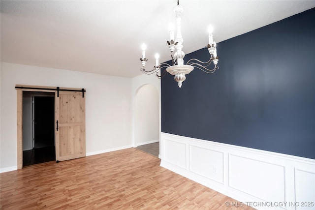 13323 S 21st St, Bixby, OK 74008 - empty room featuring a chandelier, light wood finished floors, arched walkways, and a wainscoted wall
