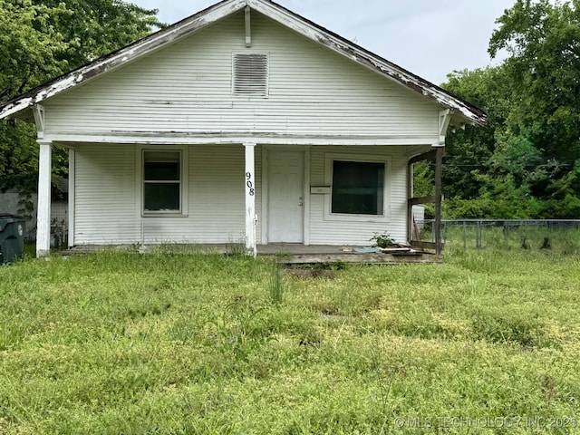 back of property with fence and a porch