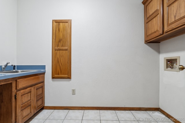 5601 S 9th E, Muskogee, OK 74403 - clothes washing area featuring washer hookup, light tile patterned floors, a sink, baseboards, and cabinet space