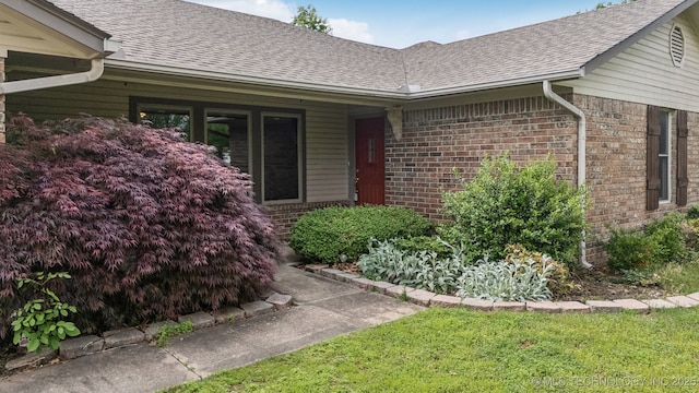 5601 S 9th E, Muskogee, OK 74403 - doorway to property featuring a shingled roof and brick siding