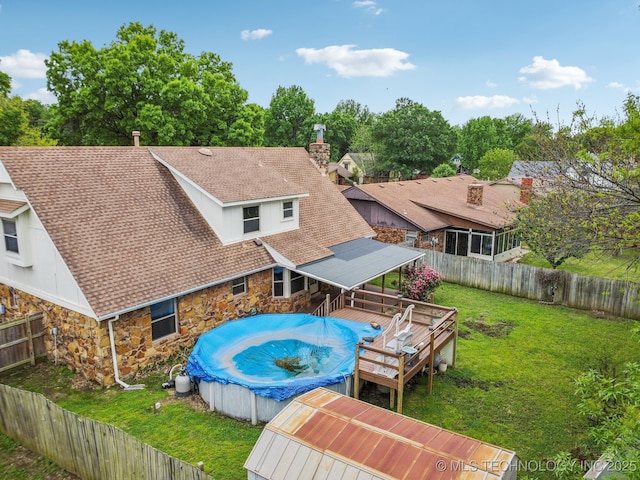 view of swimming pool featuring a deck, a fenced backyard, a yard, and a fenced in pool