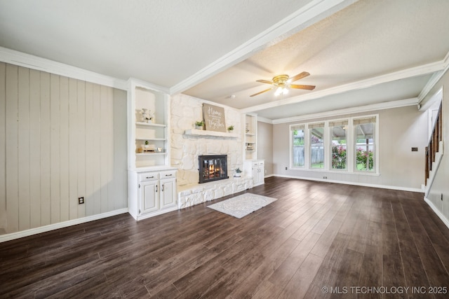 unfurnished living room featuring stairs, a ceiling fan, a stone fireplace, and dark wood-type flooring
