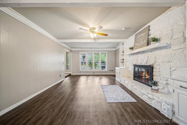 unfurnished living room featuring a textured ceiling, baseboards, a fireplace, dark wood-type flooring, and a ceiling fan