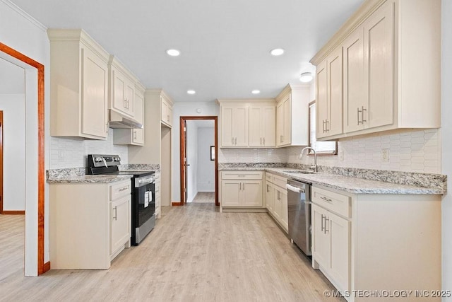 kitchen with a sink, under cabinet range hood, light wood-type flooring, tasteful backsplash, and appliances with stainless steel finishes