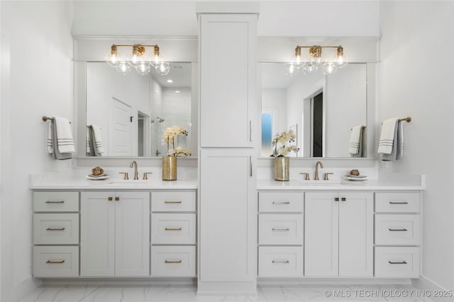full bath featuring two vanities, marble finish floor, and a sink