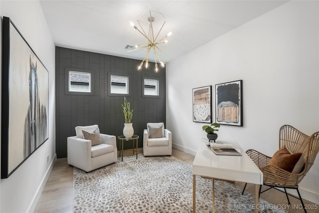 living area featuring a chandelier, visible vents, wood finished floors, and baseboards