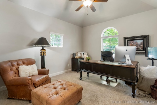 carpeted home office with ceiling fan, vaulted ceiling, and baseboards