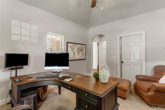 home office with arched walkways, baseboards, light carpet, and vaulted ceiling