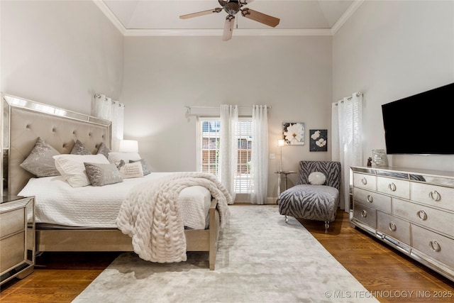 bedroom featuring a high ceiling, ornamental molding, a ceiling fan, and dark wood finished floors