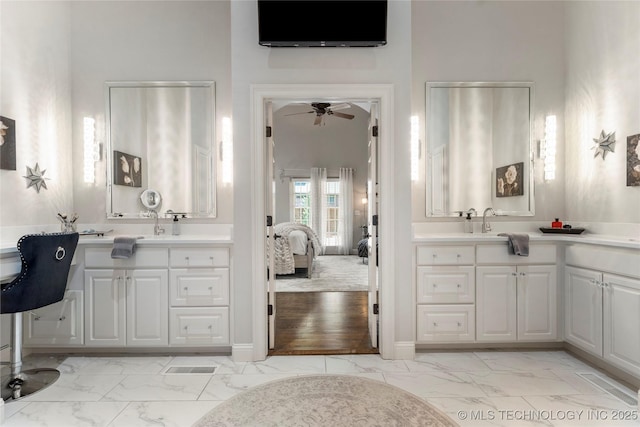 ensuite bathroom featuring ceiling fan, marble finish floor, and vanity
