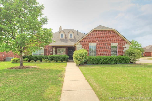 view of front of house featuring a front lawn, a chimney, and brick siding