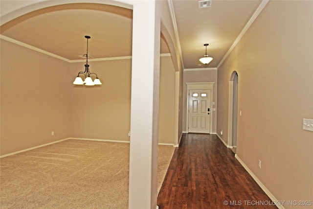interior space featuring baseboards, visible vents, arched walkways, and crown molding