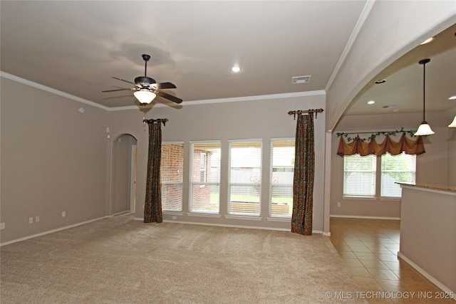 unfurnished living room featuring crown molding, arched walkways, ceiling fan, and baseboards