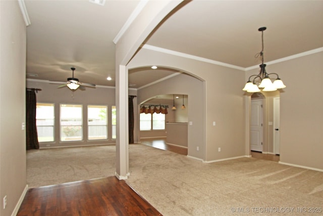 interior space with ornamental molding, carpet flooring, baseboards, and ceiling fan with notable chandelier