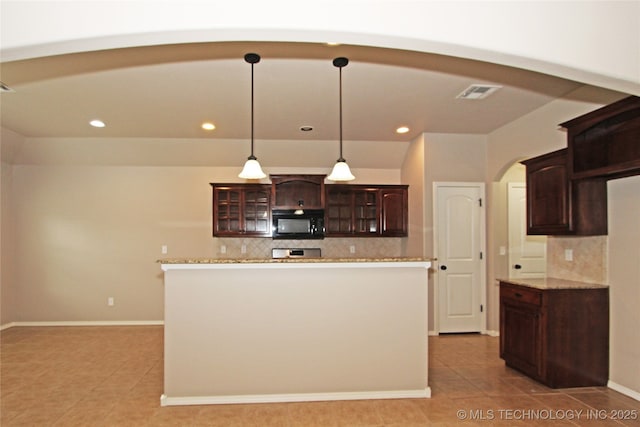 kitchen featuring arched walkways, light tile patterned floors, black microwave, backsplash, and visible vents