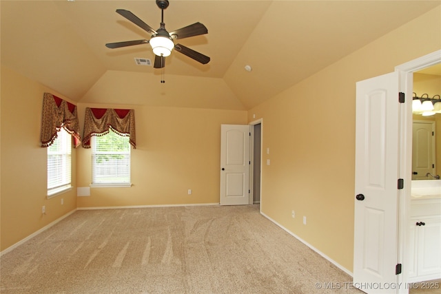 unfurnished bedroom with lofted ceiling, visible vents, baseboards, and carpet floors