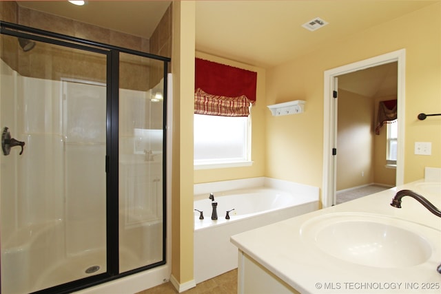 full bath featuring a wealth of natural light, a garden tub, a stall shower, and a sink