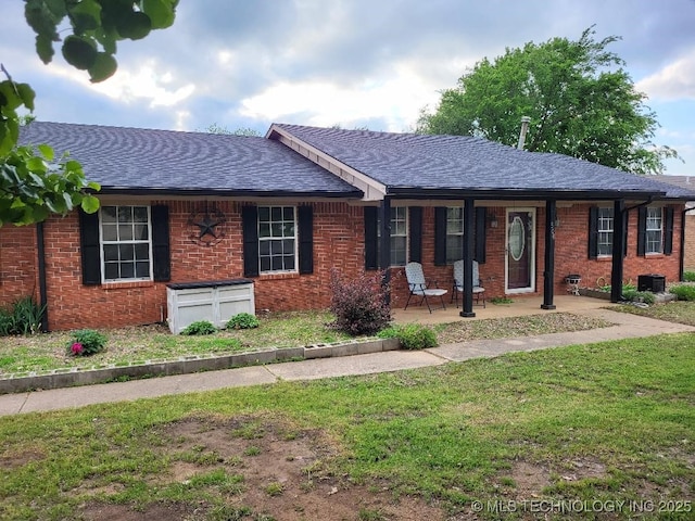ranch-style home featuring a front lawn, a porch, a shingled roof, and brick siding