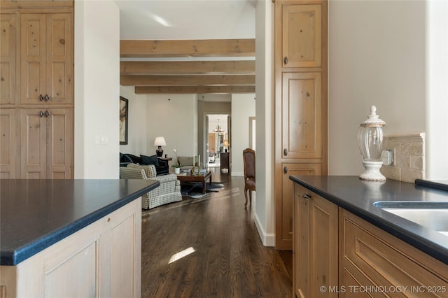 kitchen with dark countertops, beamed ceiling, open floor plan, and dark wood-type flooring