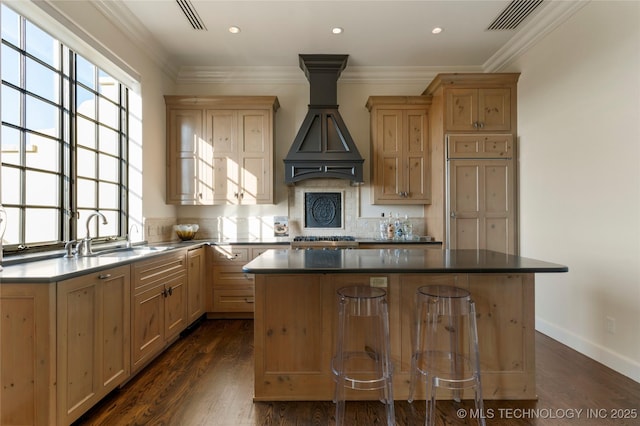 kitchen with a center island, a sink, visible vents, and tasteful backsplash
