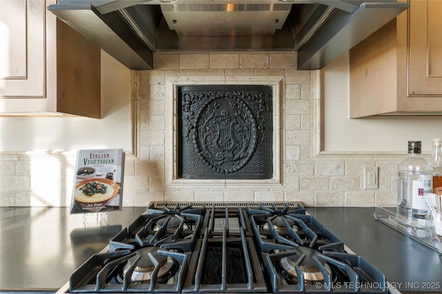 room details featuring decorative backsplash, custom exhaust hood, and gas stovetop