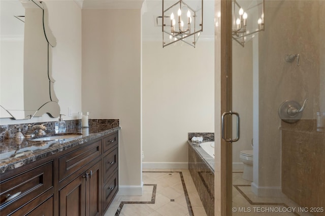 full bath featuring crown molding, baseboards, toilet, a chandelier, and a tub to relax in