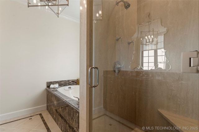 bathroom with baseboards, a bath, a stall shower, and a notable chandelier