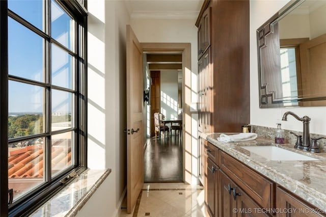 bathroom with vanity, ornamental molding, and baseboards