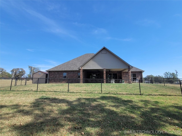 back of house with brick siding, a fenced backyard, ceiling fan, and a yard