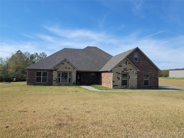 view of front of house with brick siding, roof with shingles, stone siding, and a front yard