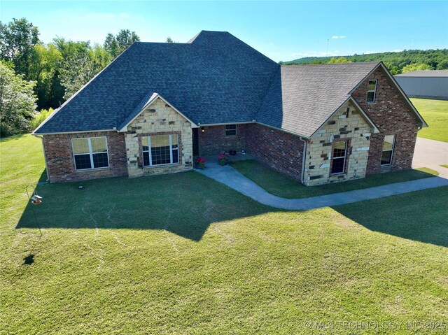2267 Krebs Lk, Mcalester, OK 74501 - view of front of property with a shingled roof, a front yard, stone siding, brick siding, and a patio