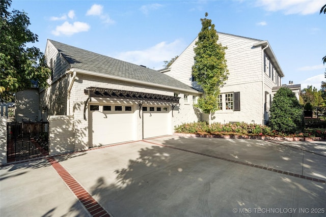 view of home's exterior with an attached garage, concrete driveway, and brick siding