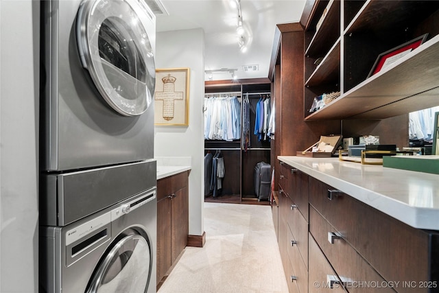 laundry room with laundry area, stacked washer and dryer, and visible vents