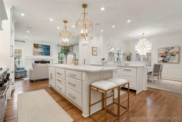 kitchen featuring open floor plan, a spacious island, white cabinetry, and a notable chandelier