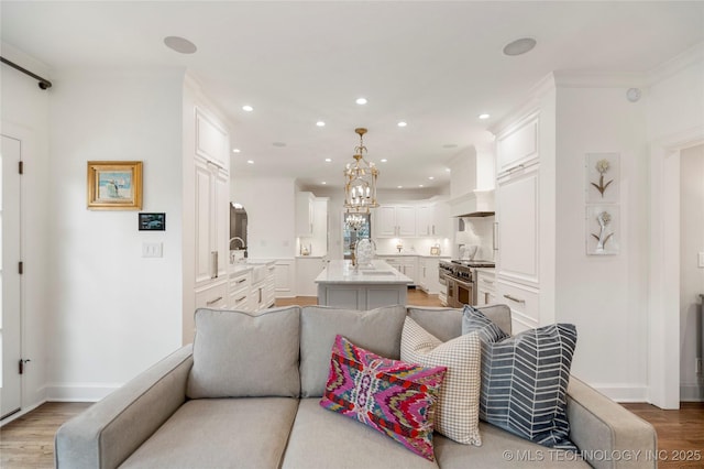living room with baseboards, ornamental molding, recessed lighting, and wood finished floors