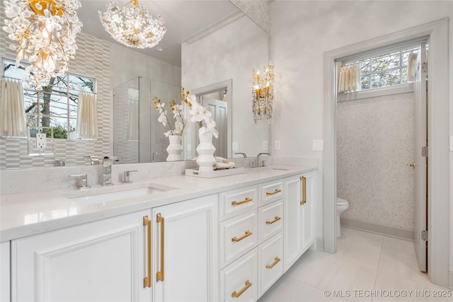bathroom featuring double vanity, tile patterned floors, a chandelier, and a sink