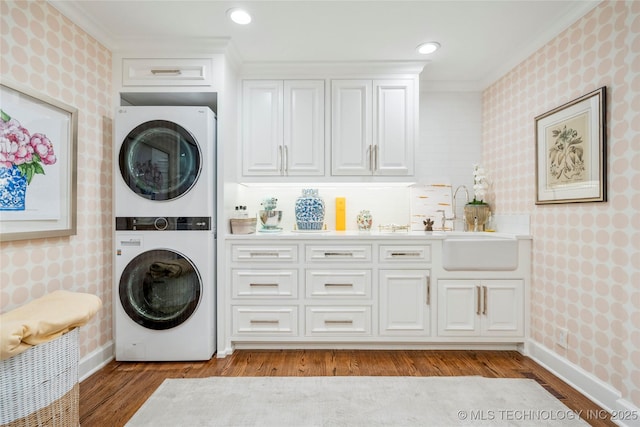 laundry area with stacked washing maching and dryer, ornamental molding, and wallpapered walls