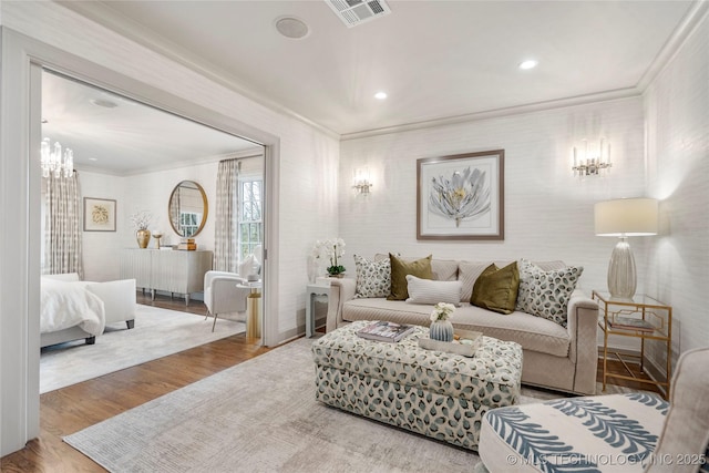 living area featuring visible vents, ornamental molding, wood finished floors, and recessed lighting