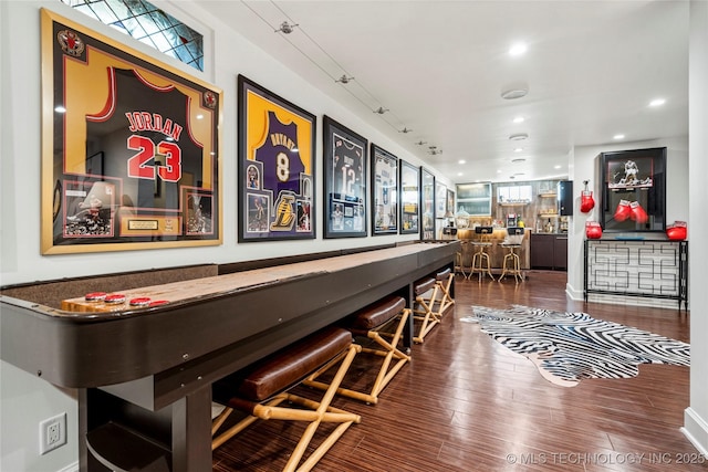 rec room featuring a bar, recessed lighting, and wood finished floors
