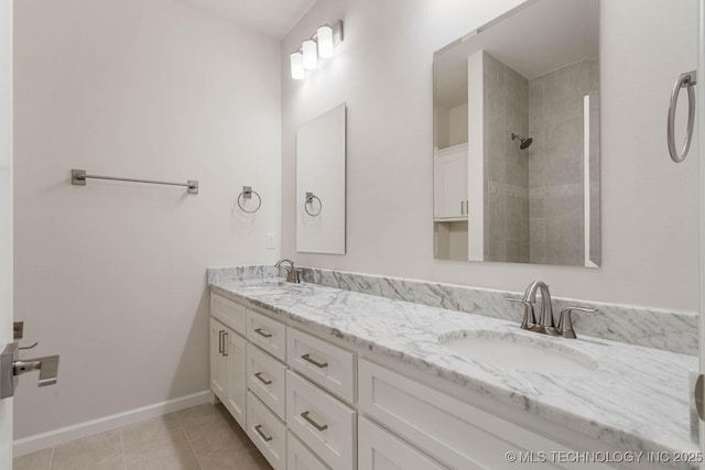 full bath with double vanity, a sink, tile patterned floors, and tiled shower